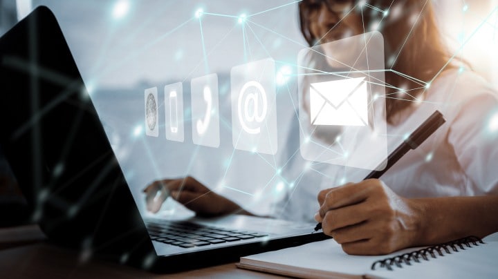 Person working on a laptop with digital communication icons